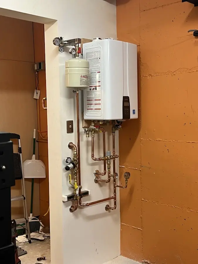 Plumbing technician inspecting water heater connections in La Feria